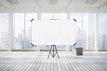 Whiteboard on tripod in bright room with city view and wooden floor with a gray cube object near