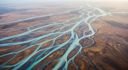 Aerial view of a complex braided river system with vibrant turquoise channels flowing through a vast landscape