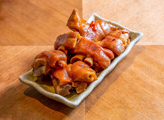 Spicy Pepper Pork Knuckle Slices on a Decorative Rectangular Plate on wooden board side view of main course