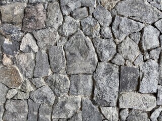  rugged and durable dry-stacked natural stone wall texture in various shades of grey and brown. Excellent as an earthy, rustic, or architectural background