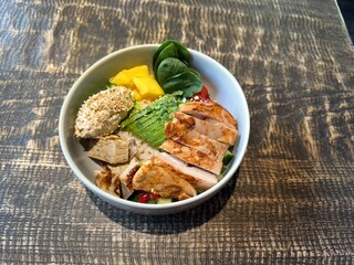 Healthy chicken bowl with avocado hummus and fresh vegetables