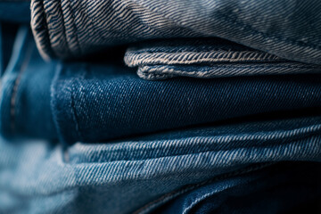 Overhead view of stacked denim jeans neatly folded. Casual clothing essentials displayed on a flat surface, perfect for fashion, retail, and lifestyle themes.
