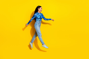 Young Woman in Blue Top Posing Joyfully Against a Bright Yellow Background for a Fashion Lifestyle Concept
