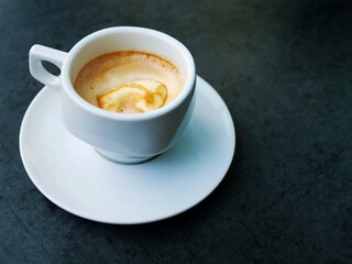 Cappuccino or latte in white cup on dark surface – frothy milk, subtle foam art, cozy coffee moment, minimal aesthetic, contrast background, café vibe, elegant drink close-up, relaxing break