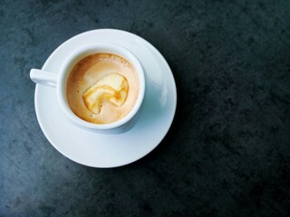 Cappuccino or latte in white cup on dark surface – frothy milk, subtle foam art, cozy coffee moment, minimal aesthetic, contrast background, café vibe, elegant drink close-up, relaxing break