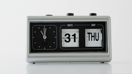 Closeup flip clock showing date time at white background. Retro vintage device