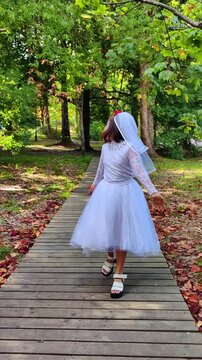 A girl in a white dress and a veil, the image of a scary bride, a zombie, dancing coolly, on Halloween