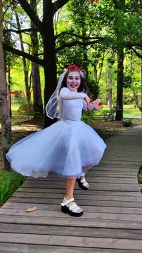 A girl in a white dress and a veil, the image of a scary bride, a zombie, dancing coolly, on Halloween