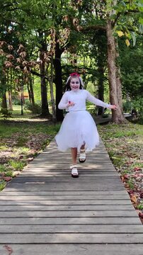 A girl in a white dress and a veil, the image of a scary bride, a zombie, dancing coolly, on Halloween