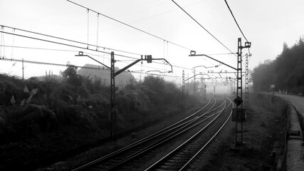 Railway line in the early morning hours, enveloped in thick fog. The shot conveys a feeling of...
