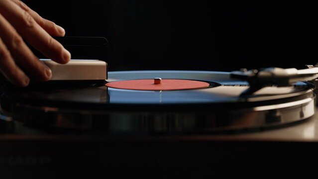 Man hand cleaning record playing on vintage turntable closeup. Macro vinyl disc
