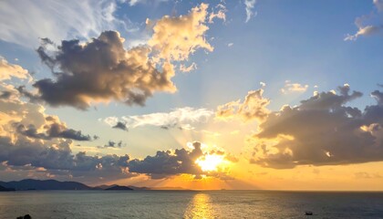 Golden hour sunset over ocean, the sun's rays peaking through clouds in the sky