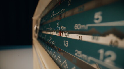 Vintage radio needle moving inside old panel indoors closeup. Finger spinning