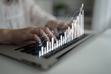 A person engages with a laptop, surrounded by digital graphs representing data analysis and business growth in a contemporary workspace setting. Impute