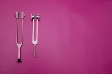 two tuning forks on pink Background, Space for Text, Space for Logo, medical instrument, medical...