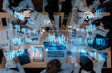 A diverse group of professionals collaborates around a table filled with financial reports and charts while digital interface overlays enhance data analysis. Trope