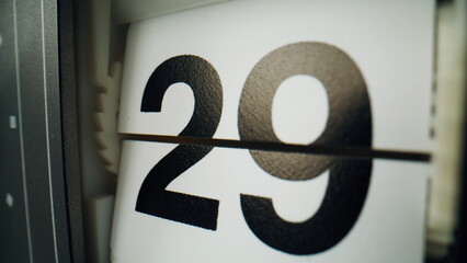 Flip clock changing panels closeup. Vintage flipclock showing black numbers