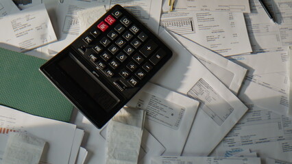 Financial sheets lying calculator sunshine top view. Disorganized workstation