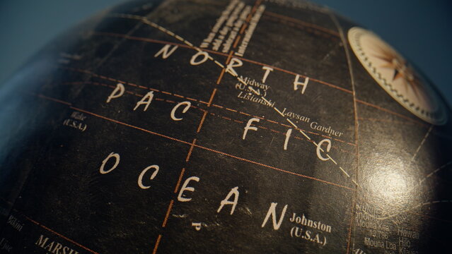 Pacific ocean marked globe dark surface closeup zoom out. Vintage Earth model 