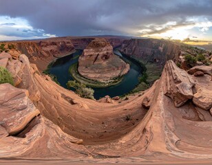 Panoramic vista of a horseshoe bend river carving through sandstone cliffs under a dramatic, partly cloudy sunset sky