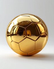A gleaming golden soccer ball, highly polished, sits on a plain white background, reflecting light