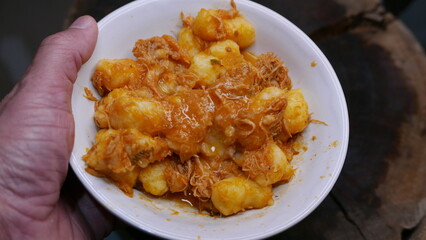 POV: Someone holding a plate of gnocchi. Close-up shot of a plate of gnocchi with chicken. Eating gnocchi.