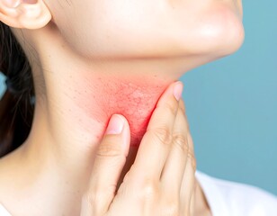 Close-up of a woman touching her red, inflamed throat