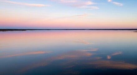Obraz premium Calm water reflects the beautiful sunset colors.