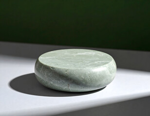 Smooth Green Stone on Minimalist Surface with Shadow Play