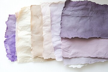 Obraz premium A collection of hand-crafted papers, exhibiting a spectrum of muted lavender, beige, and cream tones.