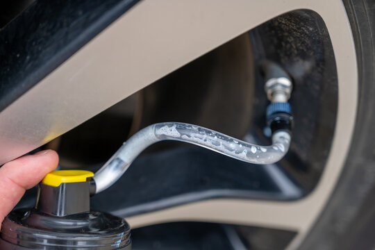 Fototapeta Selective focus on chemical additive sprayed from a can into a tire to fix a flat 