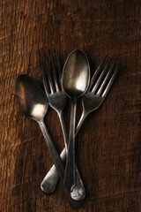 Antique Flatware Still Life. Hig angle shoto of two spoons and two forks on a rustic wooden table.