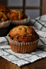 Muffin Still Life. Closeup of a fresh homemade Banana Nut Muffin with out of foucs muffins and window behind.