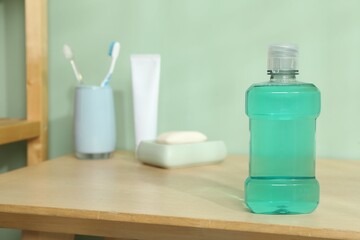 Bottle of mouthwash on wooden shelf in bathroom