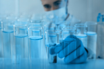 Laboratory analysis. Many test tubes, double exposure with scientist