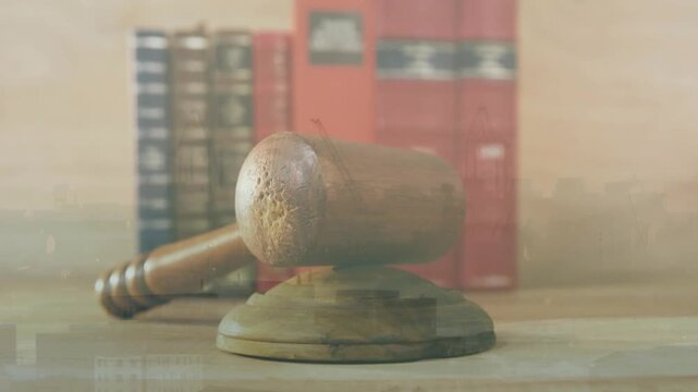 Camera opening on gavel block amid law books, holding steady changing lighting displaying grain