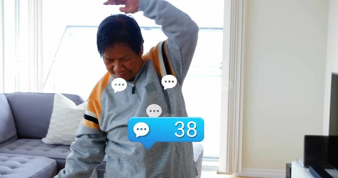 Senior woman raising arms and activating floating blue comment bubble tracking reps during fitness