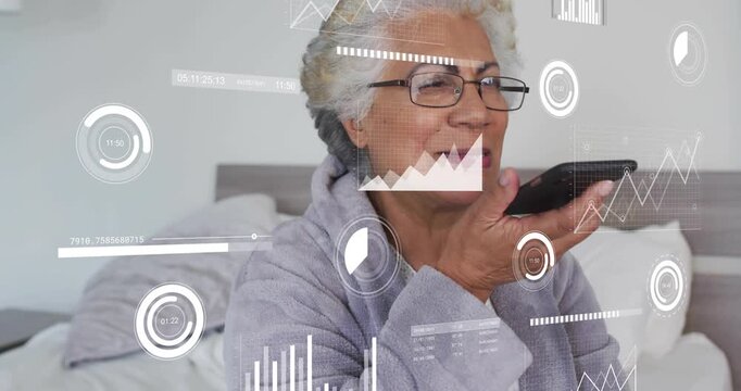senior woman raising phone in bed issuing assistant command tracking progress, viewing charts - Powered by Adobe