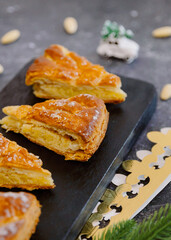 Four pieces of biscuits with a crown, a toy and an almond on the table.