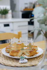 A cut royal galette with a golden crown on a table in the kitchen.