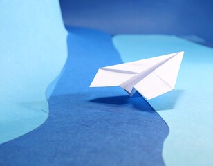 Paper airplane on a blue backdrop