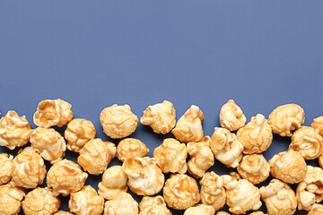Crispy popcorn on blue background, closeup