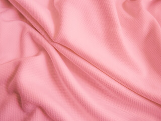 Pink crumpled  fabric background. Wavy cloth texture