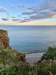 Scenic coastal landscape at sunset with rugged cliff edge 