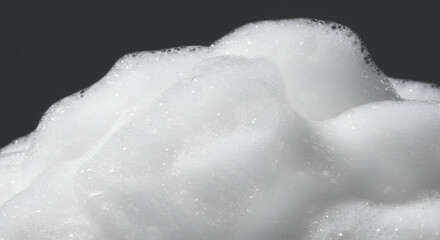 Fototapeta premium Close-up of luxurious white foam with soft bubbles against a dark background