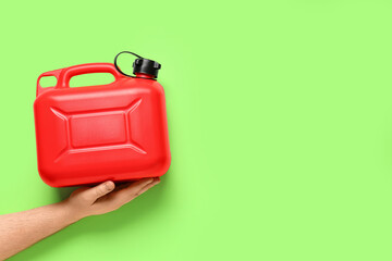 Male hand holding canister on green background