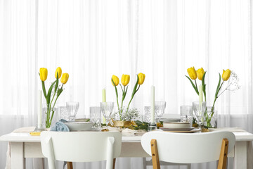 Elegant table setting with beautiful tulip flowers and candles in restaurant