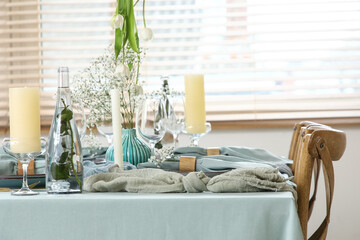 Elegant table setting with beautiful flowers, candles and folded napkins in restaurant