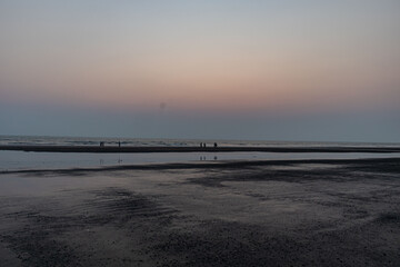 Naklejka premium Perfect Sunset Stroll Along the Calm Cox’s Bazar Beach, Bangladesh.