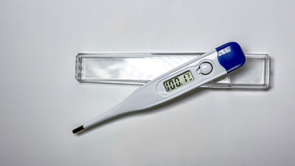 Obraz premium Digital medical thermometer with blue cap isolated on white background